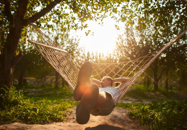 Blurry And Defocus Relaxing In Hammock In Sunny Day. Man Rest In